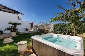 A hot tub in a backyard with a white house, a pergola, and potted plants. - 3672 Villa Acquamarina by Barbarhouse (Porto Cesareo)