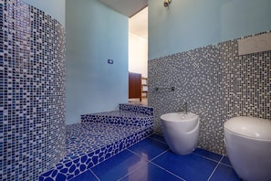 A bathroom with mosaic tile walls, a white sink, and a toilet. - 3672 Villa Acquamarina by Barbarhouse (Porto Cesareo)