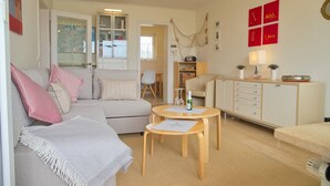 Een gezellige woonkamer met een bank, een salontafel en een kast.
