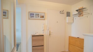 Een kamer met een houten kast, een witte deur en een klein plankje met een fotolijstje.