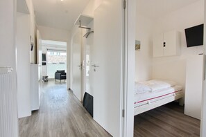 Ein Hotelzimmer mit Bett, Wandfernseher und Blick ins Freie.