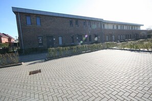 Ein modernes Gebäude mit Ziegelverkleidung und einem gepflasterten Innenhof.