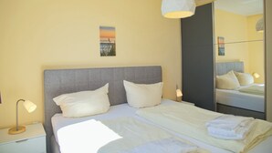 Ein Hotelzimmer mit einem Bett, einer Nachttischlampe und einem großen Spiegel.