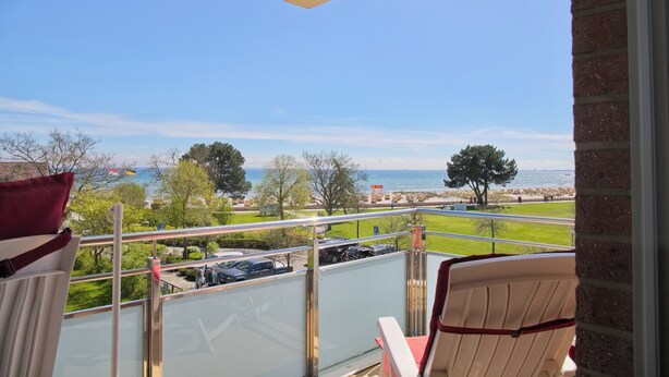 Ein Balkon mit Blick auf das Meer und einen Park.