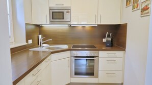 Eine moderne Küche mit Mikrowelle, Backofen, Spüle und Edelstahlgeräten.