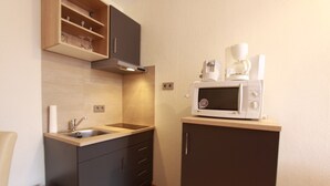 A compact kitchen with a microwave, coffee maker, and a sink. - Dornröschen Wohnung 3 (Grömitz)