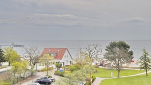Un quartiere residenziale con case, una strada e un corpo d'acqua sullo sfondo.