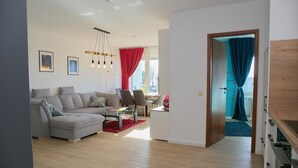 Una sala moderna con un sofá seccional gris, una mesa de centro y un comedor con sillas.