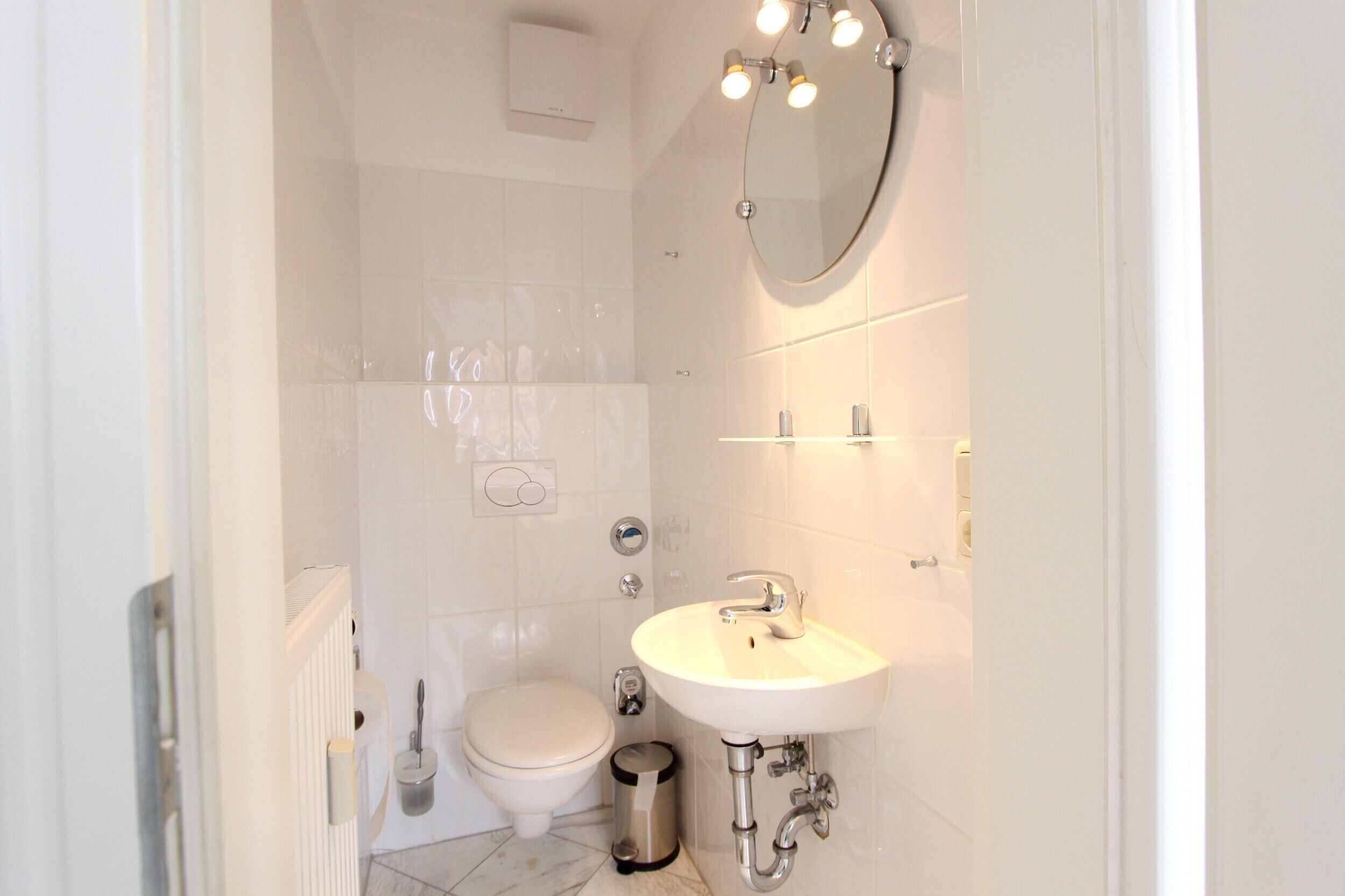 A modern bathroom with a toilet, sink, and shower.