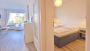 Una camera d'albergo moderna con un letto, un comodino e vista sull'esterno.