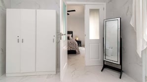 A bedroom with a bed, a wardrobe, and a mirror. - Villa Melua (Chayofa)