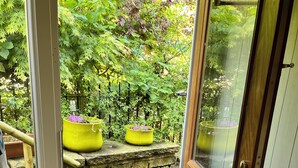 A wooden door leading to a garden with a stone wall and two yellow flower pots. - Royd Villas,Spacious &Quiet,Log Burner,Patio & TV bed in Centre of Hebden Bridge (Hebden Bridge)
