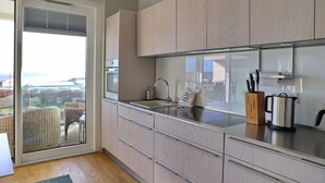 A modern kitchen with a large window, sliding glass door, and a view of the outdoors.