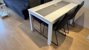 A modern living room with a white dining table, dark grey sofa, and black chairs. - Hanseat I Appartement. 79 (Grömitz)