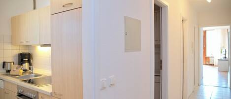 A modern kitchen with wooden cabinets, a built-in oven, and a stainless steel sink.