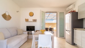 Una cocina moderna con comedor, sofá y televisor.