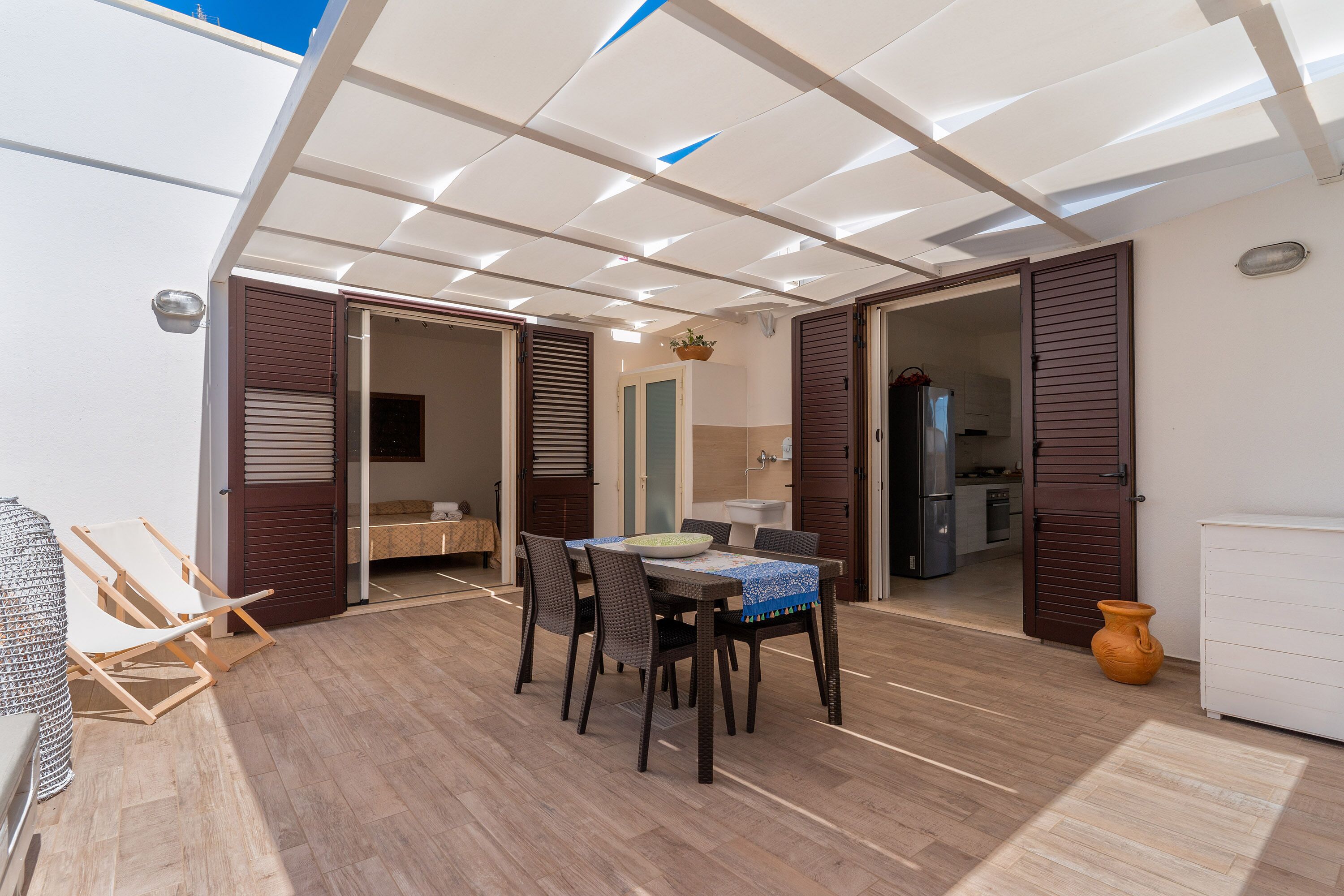 A dining area with a table and chairs, a ceiling with recessed lighting, and wooden flooring.