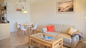 Una sala de estar con sofá, mesa de centro y comedor.