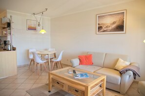 Ein Wohnzimmer mit einer Couch, einem Couchtisch und einem Essbereich.