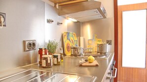 A kitchen with stainless steel appliances, a wooden cutting board with a lemon, and various kitchen items. - Haus Belvedere App. 63 (Grömitz)