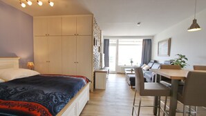 Une chambre d’hôtel moderne, dotée d’un grand lit, d’un bureau et d’un coin repas.
