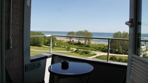 Un balcon avec vue sur la mer et un parc.