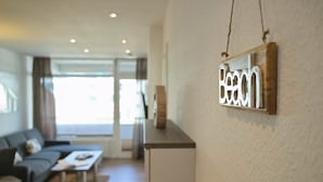 Una sala de estar moderna con un sofá, una mesa de centro y un cartel en la pared que dice "Beach".