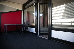 Enjoy a compact room with a desk, chair, and balcony access, perfect for work or relaxation.
