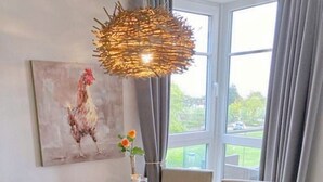 Et spisebord dækket med tallerkener, bestik og en vase med blomster.