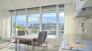 Cozinha moderna com uma mesa de jantar grande, cadeiras e vista para o exterior.