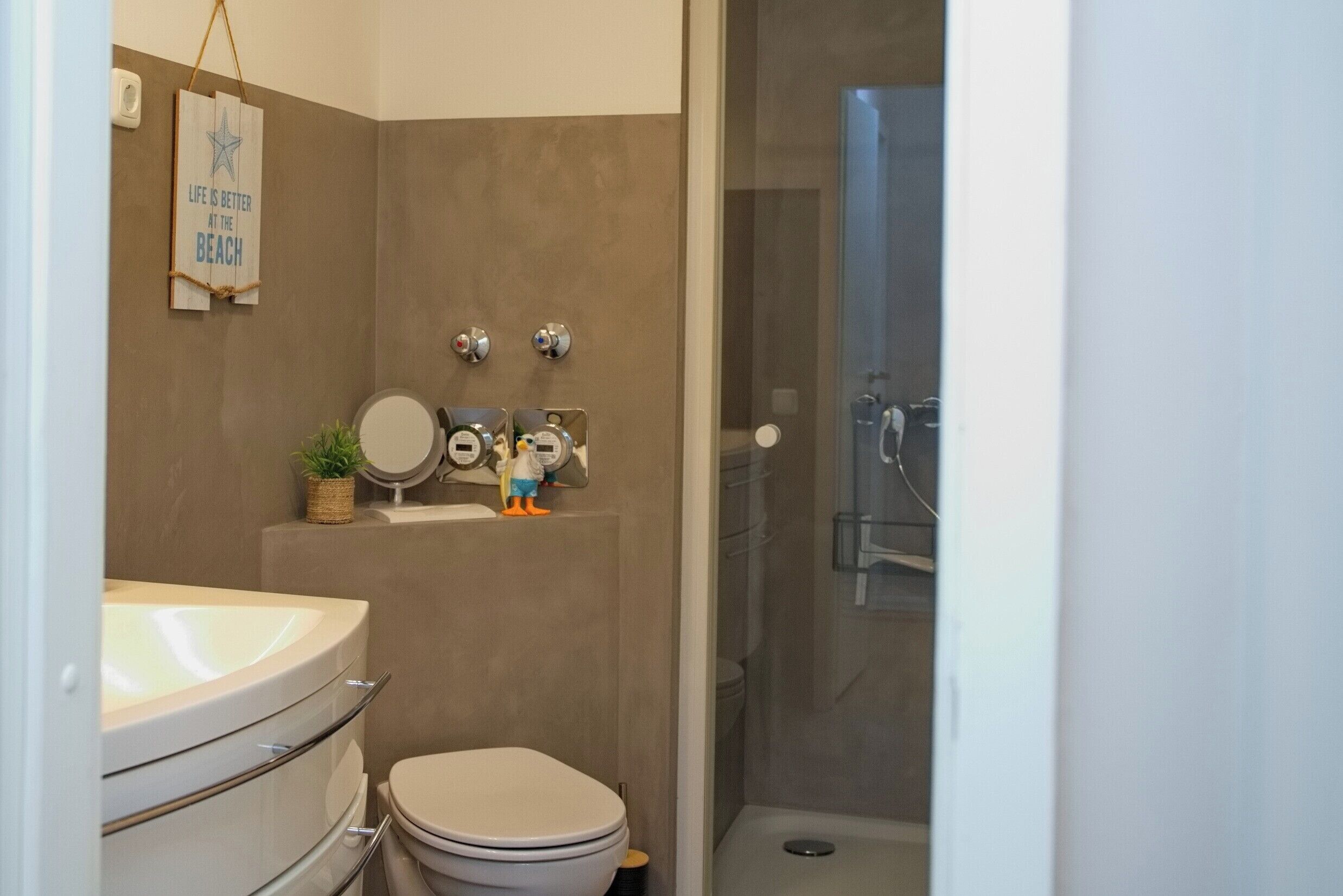 A bathroom with a toilet, sink, and shower.