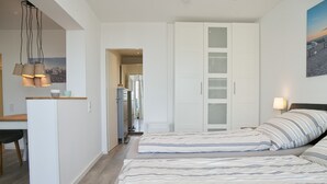 A bedroom with two beds, a desk, and a wardrobe. - Tannenburg 505 Inkl. Wlan (Grömitz)