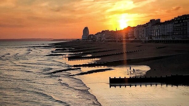 A coastal sunset view with a beach, a pier, and buildings in the background. - Gensing Lodge A Beautiful 3 Bedroom Boutique. Award Winning!  (Saint Leonards)