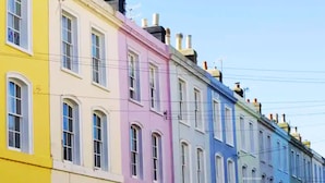 A row of colorful buildings with arched windows and a clear sky. - Gensing Lodge A Beautiful 3 Bedroom Boutique. Award Winning!  (Saint Leonards)