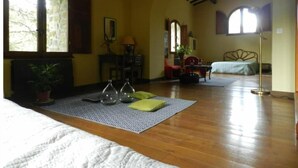 A room with a wooden floor, a bed, a desk, a chair, a window, and a ceiling fan. - Gîte Cévennes: Piscine, Lamas, Rivière (Cros)