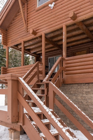 Eine Holzhütte mit einer Treppe, die zu einer Veranda führt.