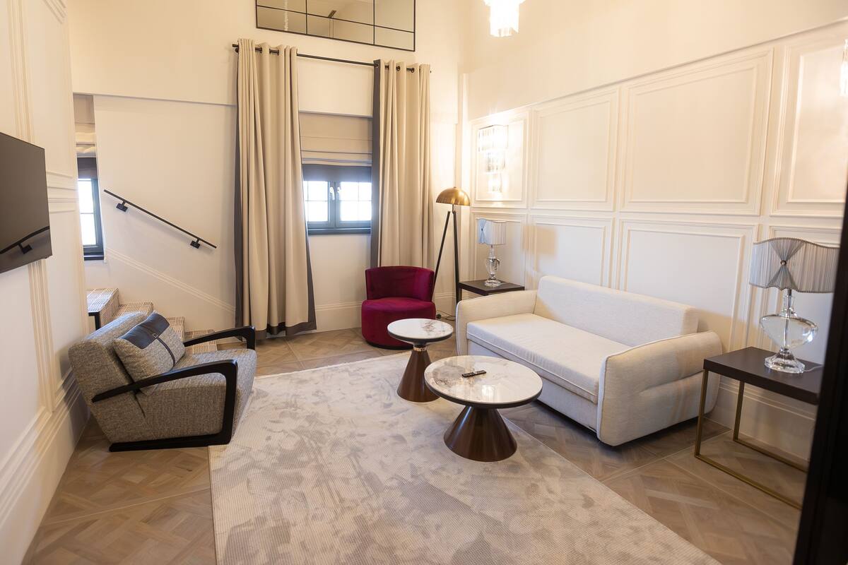 A modern living room with a sofa, armchair, coffee table, and floor lamp.