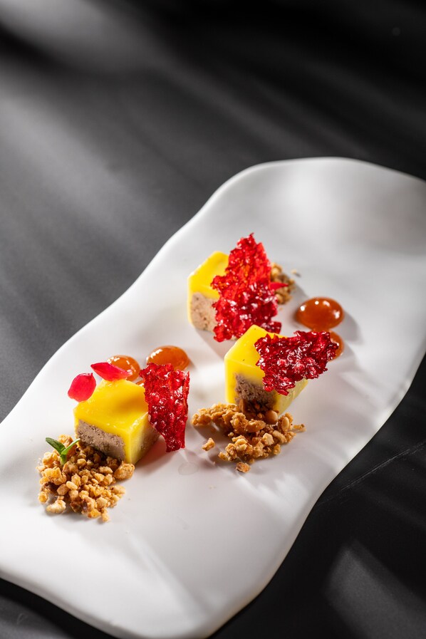 Un postre sobre un plato rectangular blanco con fondo oscuro.