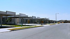A modern building with a covered walkway and a parking lot. - Beautiful apartment 9 min to Mercedes outlets (Weslaco)