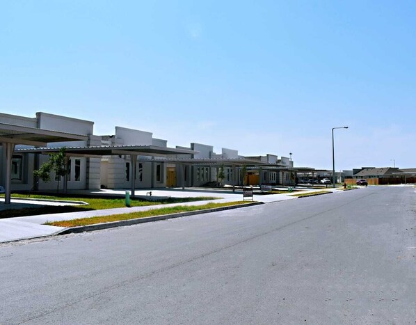 A modern building with a covered walkway and a parking lot.