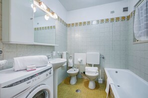A bathroom with a washing machine, sink, bidet, toilet, and bathtub. - Snow White Near Slopes of Campo Smith (Bardonecchia)