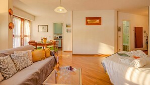 Una camera d'albergo con divano, letto, tavolo da pranzo e angolo cottura.