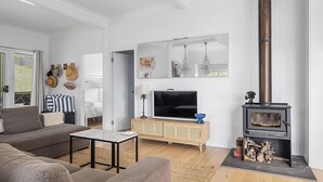 Una sala de estar moderna con un sofá, una mesa de centro, un televisor, una chimenea y un mueble de madera.