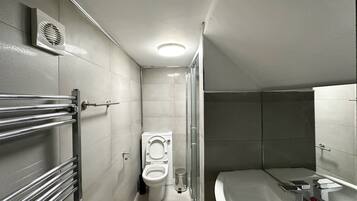 Een moderne badkamer met toilet, douche en bad.