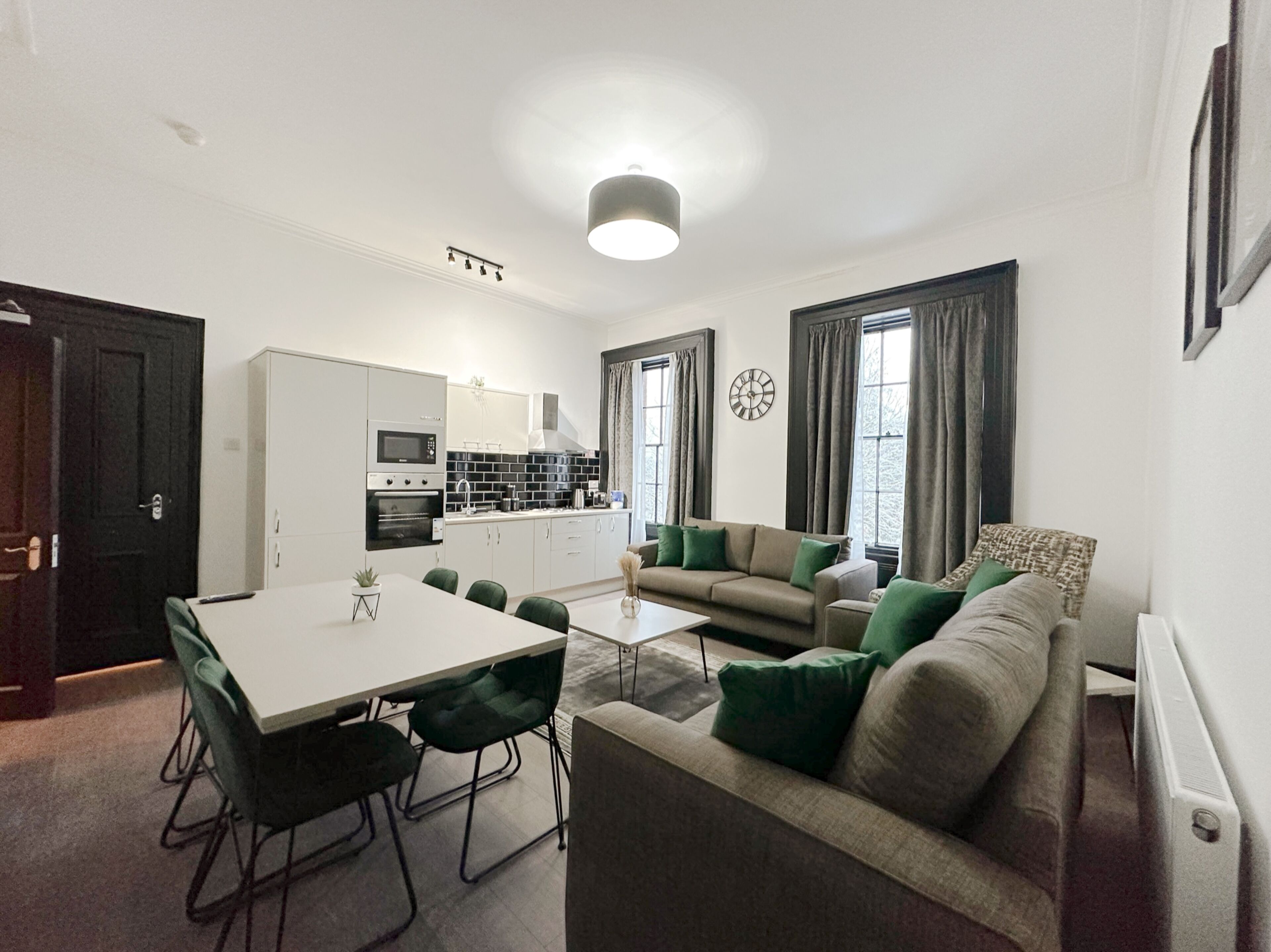 A modern apartment with a dining area, kitchen, and living room.