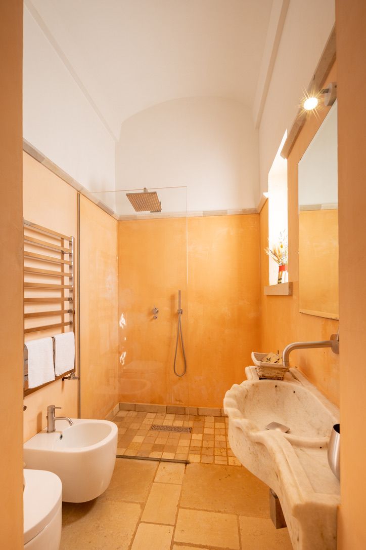 A bathroom with a shower, a sink, and a bidet.