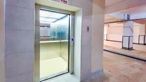 Puerta de ascensor de vidrio con un letrero que dice "NO POWER", suelo de baldosas y un respiradero metálico en el techo.