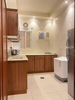 Una cocina con armarios de madera, horno empotrado, fregadero y refrigerador.