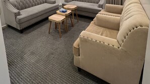 Ein modernes Wohnzimmer mit einem grauen Ecksofa, einem beigefarbenen Sofa und einem kleinen Holztisch.