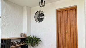 A wooden door with a brass handle, a potted plant, a metal lantern, and a welcome mat with the word "hello" on a tiled floor. - Preciosa Casa Rural en El Ronquillo (El Ronquillo)
